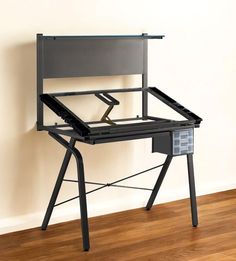 a computer desk with a drawer underneath it on a hard wood floor next to a wall