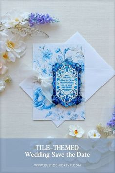 wedding save the date card with blue and white flowers on it, next to an envelope