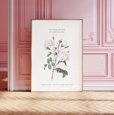 a pink room with a white framed flower print on the wall and wooden flooring