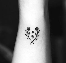 a black and white photo of a flower tattoo on the left side of the wrist