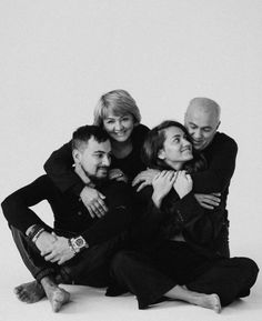 black and white photograph of four people hugging each other