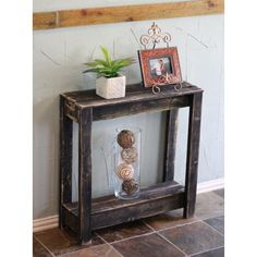 a small wooden shelf with some plants on top