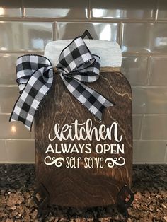 a wooden sign that says kitchen alwayss open self service with a bow on it