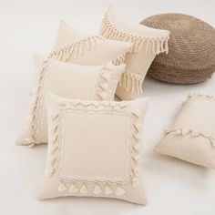 four pillows and a hat on a white surface