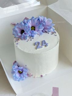 a white cake with purple flowers on top