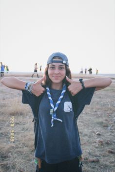 a young woman standing in the middle of a field with her hands on her hips