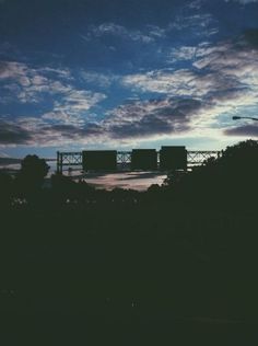 the sky is dark and cloudy with some clouds in it, as well as an overpass