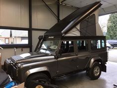 a black land rover is parked in a garage