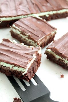 chocolate cake with white frosting on top being held by a fork