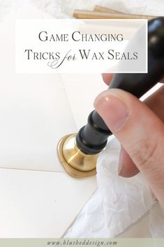 a person is holding a wax seal in their hand with the words game changing tricks for wax seals