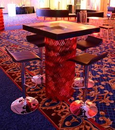 a table with four stools in front of it on a carpeted room floor