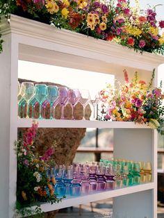 the shelves are filled with different colored glassware