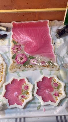 pink and white plates with flowers on them sitting on a table next to other items