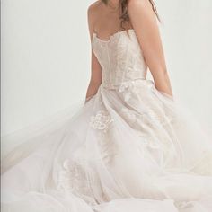 a woman in a wedding dress sitting down