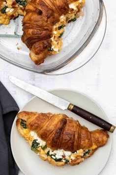 two plates with croissants on them next to a knife