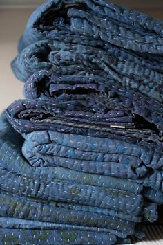 a pile of folded blue cloths sitting on top of each other