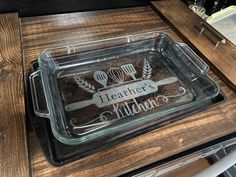 a clear tray that has some food in it on top of a wooden table with utensils