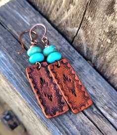 These earrings feature a hand stamped southwestern design and are dyed a medium brown and are topped with genuine Kingman mine turquoise beads...earrings hang from hand formed copper French style ear wires... Big enough to be seen yet super lightweight!  You'll reach for these earrings day after day.  *Please be aware of and allow for slight natural color variations in the turquoise.   Do you have sensitive ears?  I offer titanium ear wires and am happy to replace them on these earrings.  Simply Bohemian Turquoise Hand-tooled Earrings, Artisan Stamped Brown Jewelry, Brown Stamped Jewelry For Festivals, Stamped Brown Jewelry For Festival, Turquoise Bead Earrings, Earrings Western, Cowgirl Gifts, Cowgirl Jewelry, Turquoise Heart