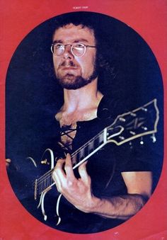 a man with glasses playing an electric guitar