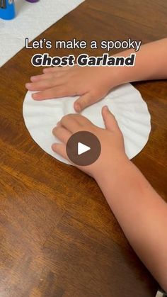 a child's hand on a paper plate with the words let's make a spooky ghost garland