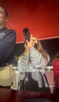 a man and woman taking pictures on their cell phones while standing next to each other