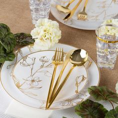 a table setting with flowers and goldware