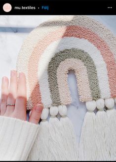 a woman's hand is holding onto a rug with tassels on it