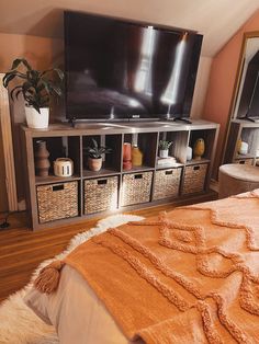 a bedroom with a large flat screen tv sitting on top of a dresser