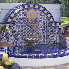 an outdoor fountain with blue and yellow tiles