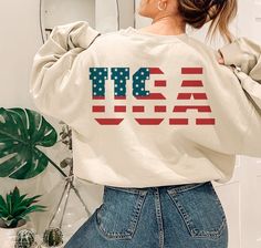 a woman with her back to the camera, wearing a sweatshirt that says tic usa