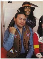 two men in cowboy hats and vests posing for a photo with one man holding his arm around the other