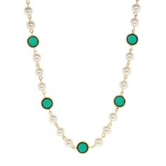 a long necklace with pearls and green stones on the link, hanging from a gold chain