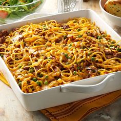 a casserole dish with noodles, meat and vegetables in it on a table