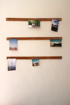 three wooden shelves with pictures hanging on them and some magnets attached to the wall