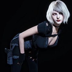 a woman with blonde hair and black clothes posing for a photo in front of a black background