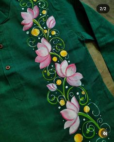 a green shirt with pink flowers painted on it