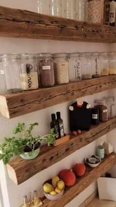 three wooden shelves filled with jars and containers on top of a wall next to a toilet