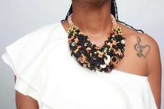 Meet "Itoro"! Her name means Praise in the African language. She is what we like to call a handmade beautiful mess of vibrant black seed beads embellished with a variety of ethnic beads that adds a unique flare. She is the epitome of statement fashion jewelry that adds the perfect pop of color to any outfit. Pair her with a nice denim button-up top or solid color blouse of choice and you are sure to command any room you enter! Features: Black; Multi-colored ethnic beads & shells; Silver fish Black Bohemian Beaded Bracelet With Colorful Beads, Artisan Black Beaded Bracelets With Colorful Beads, Unique Black Beaded Bracelets With Colorful Beads, Unique Black Beaded Bracelet, Traditional Black Beaded Bracelets With Large Beads, Artisan Black Beaded Chain, Black Bohemian Beads For Festivals, Artisan Black Beaded Necklaces For Festivals, Black Polished Beads For Festivals