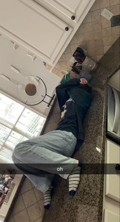 a person laying on the ground in a kitchen