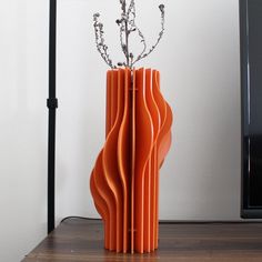 an orange vase sitting on top of a wooden table