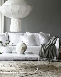 a living room filled with white furniture and pillows