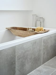 a bathtub with a bowl of popcorn in it and two vases on the wall