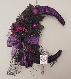 a purple and black halloween wreath on a wall