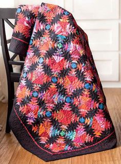 a black chair with a colorful quilt on it