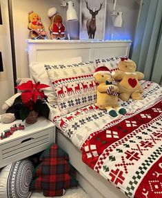 two teddy bears sitting on top of a bed in a room with christmas decorations and lights