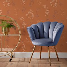 two chairs in front of a wall with faces drawn on it and a gold stand holding a potted plant