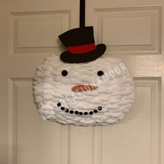 a snowman door hanger with a top hat on it's head and nose