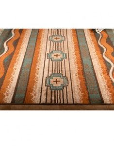 an orange, blue and white rug on a wooden floor with fringes in the middle