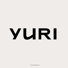 the word yuri is written in black and white on a light gray background,