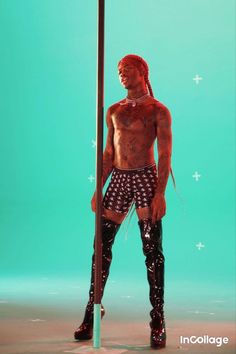 a man with no shirt standing next to a pole